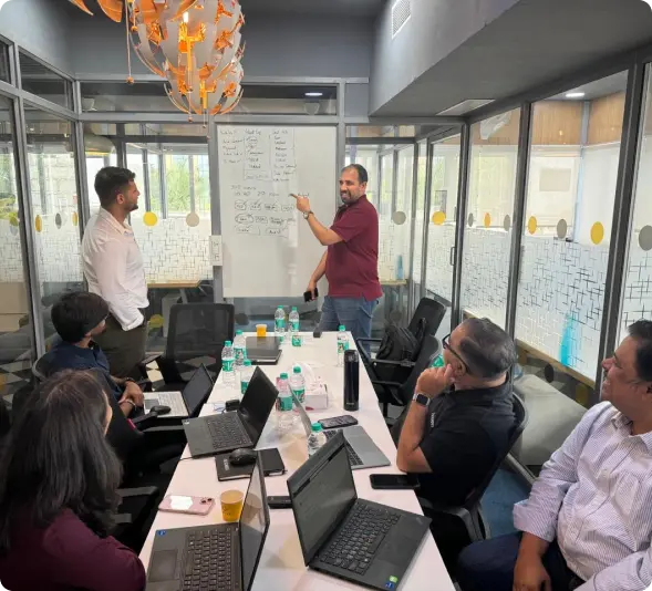 Team meeting in modern office, professionals discussing strategy on whiteboard with diagrams and flowcharts