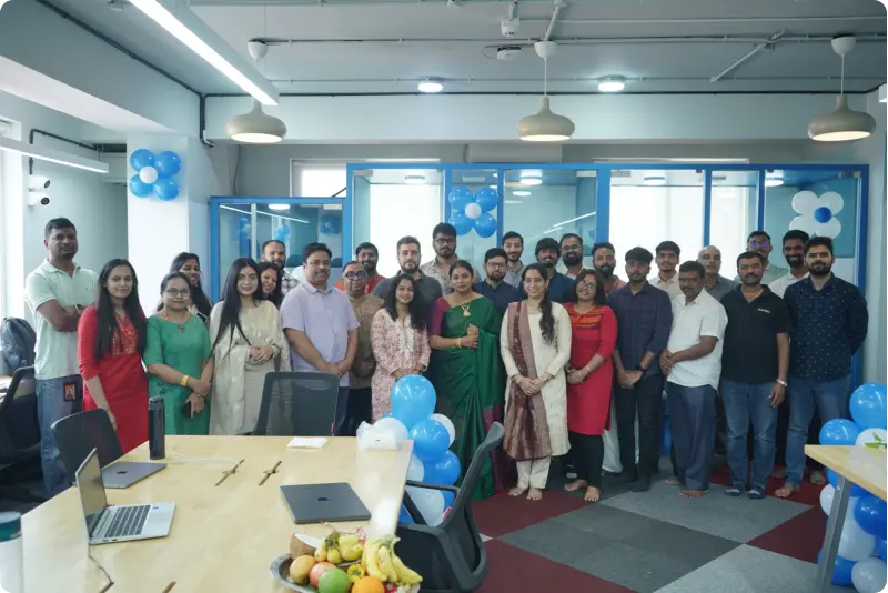 Augnito team at office decorated with blue and white balloons, celebrating company milestone