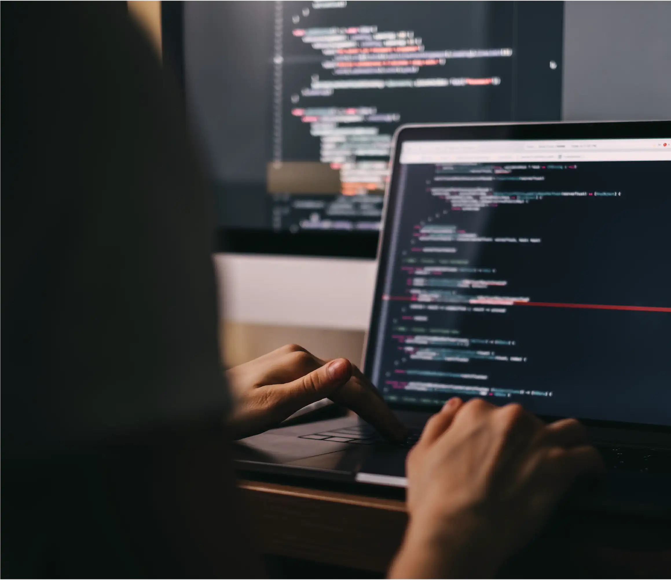 Developer coding on laptop, displaying complex programming syntax for advanced software integration