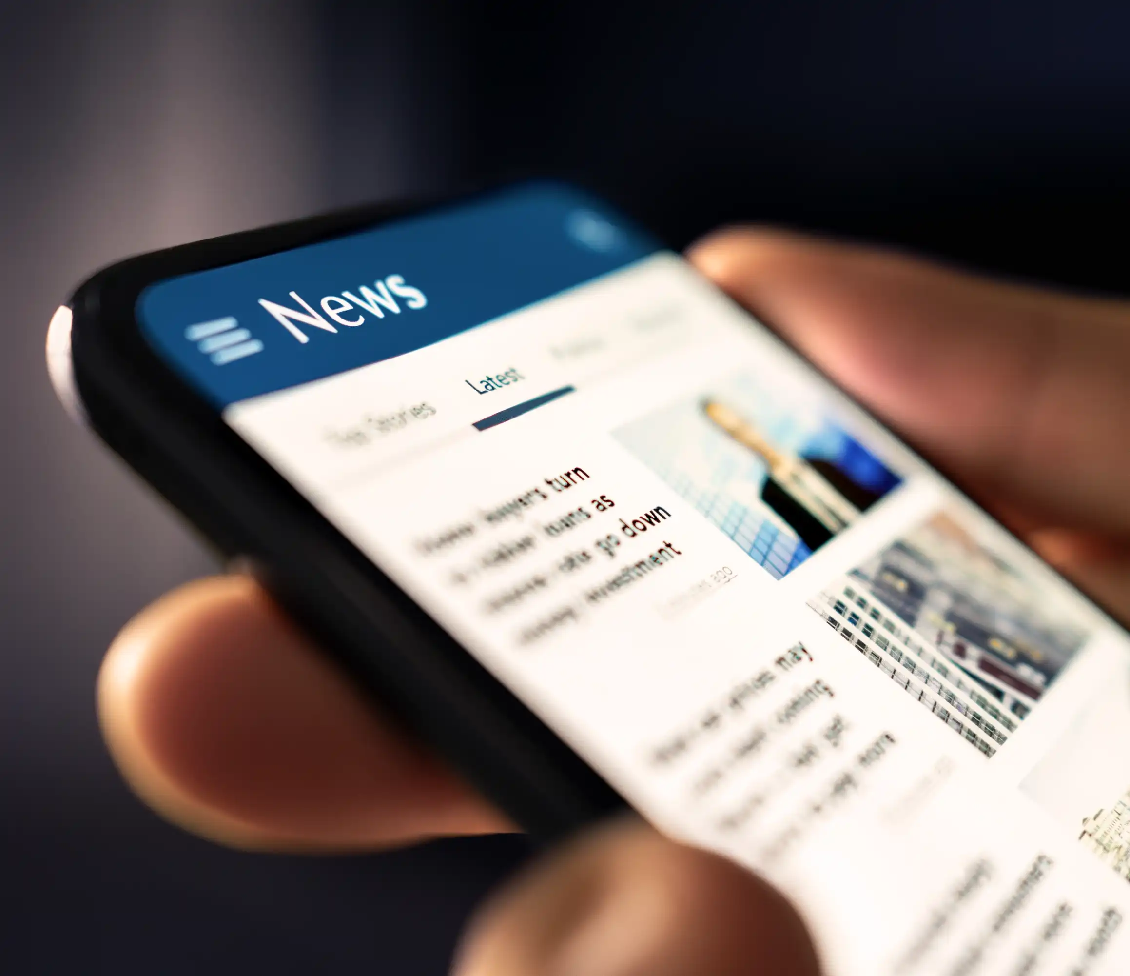 Hand holding smartphone displaying news app with latest headlines and images